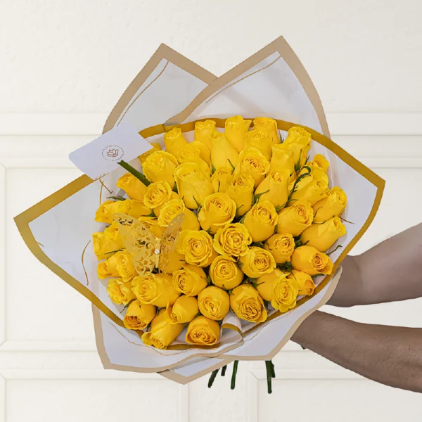 ramo buchón pequeño de 50 rosas de color amarillo con papel coreano blanco con filo dorado que envuelve el ramo, en el ramo encuentras una mariposa dorada y una nota personalizada