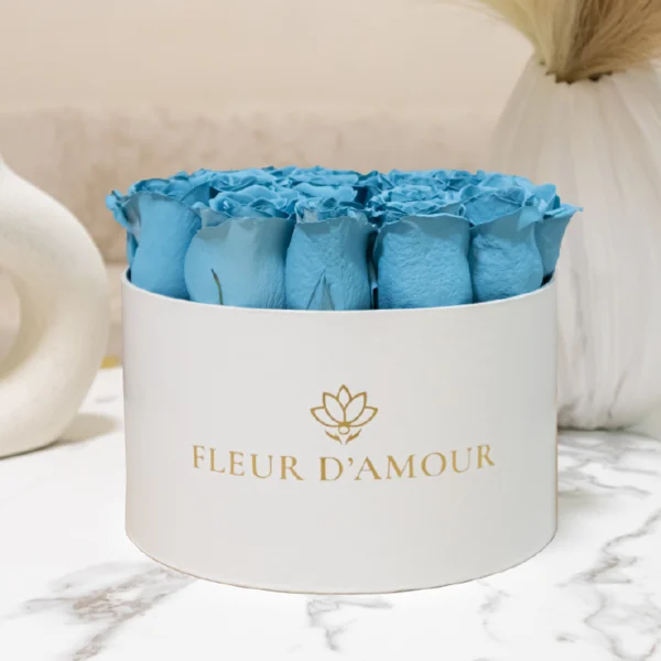 arreglo floral en caja blanca, contiene rosas celestes, vista de frente